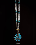 Necklace with turquoise beads and pendant on a black background