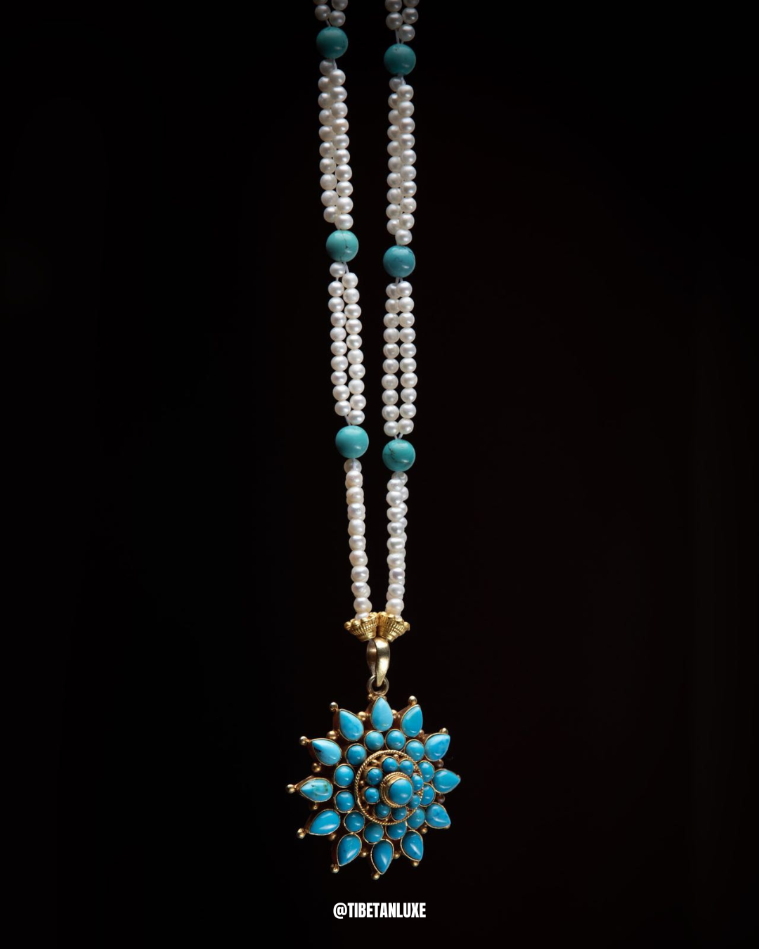 Necklace with turquoise beads and pendant on a black background