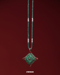 Necklace with a green pendant on a red background
