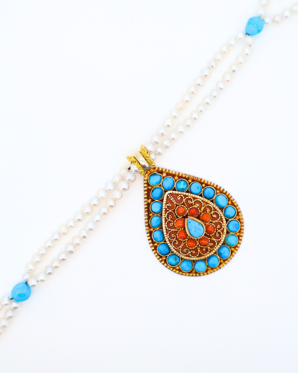 Decorative necklace with a teardrop-shaped pendant featuring blue and orange stones on a white background.