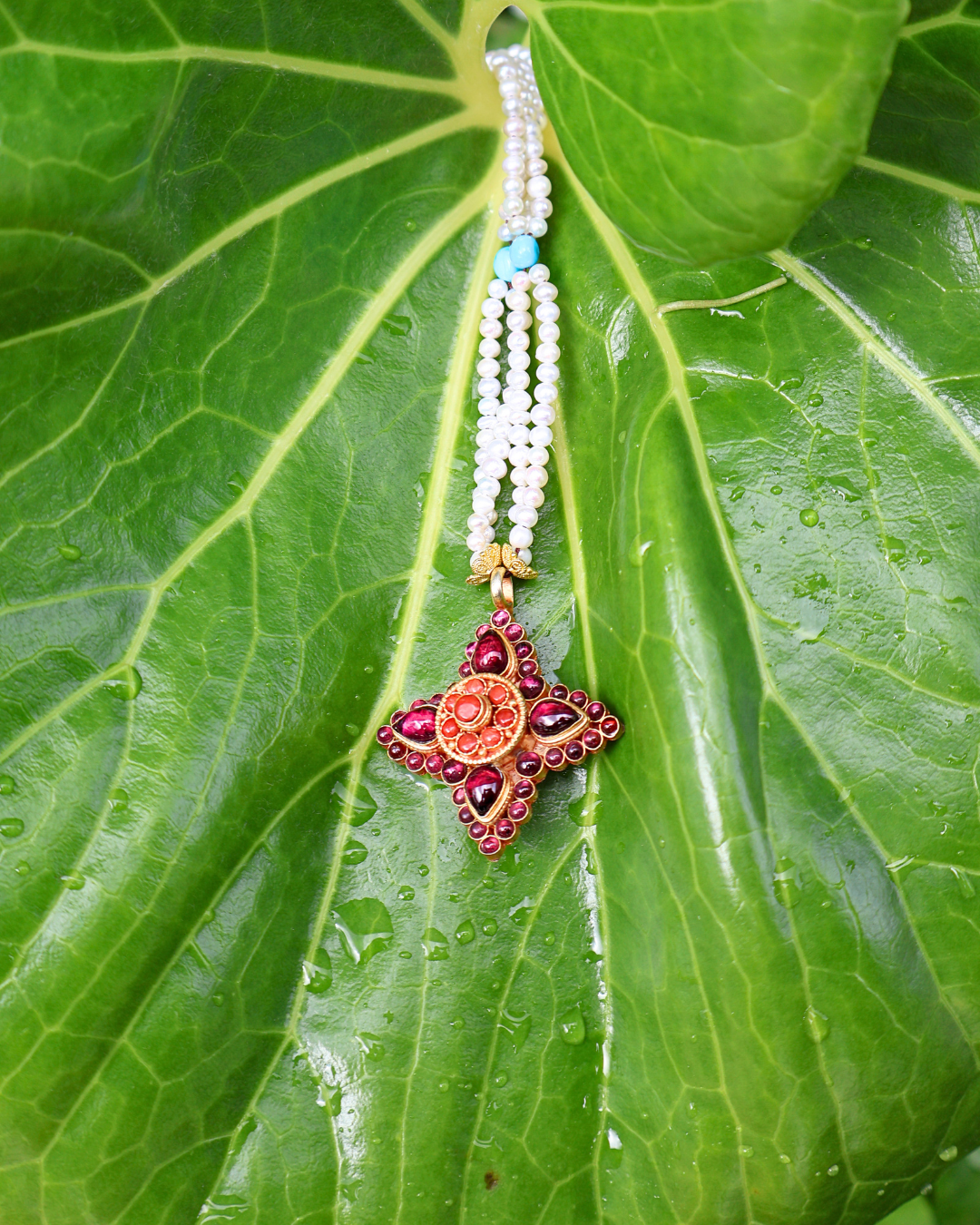 Decorative necklace with a star-shaped pendant on a green leaf