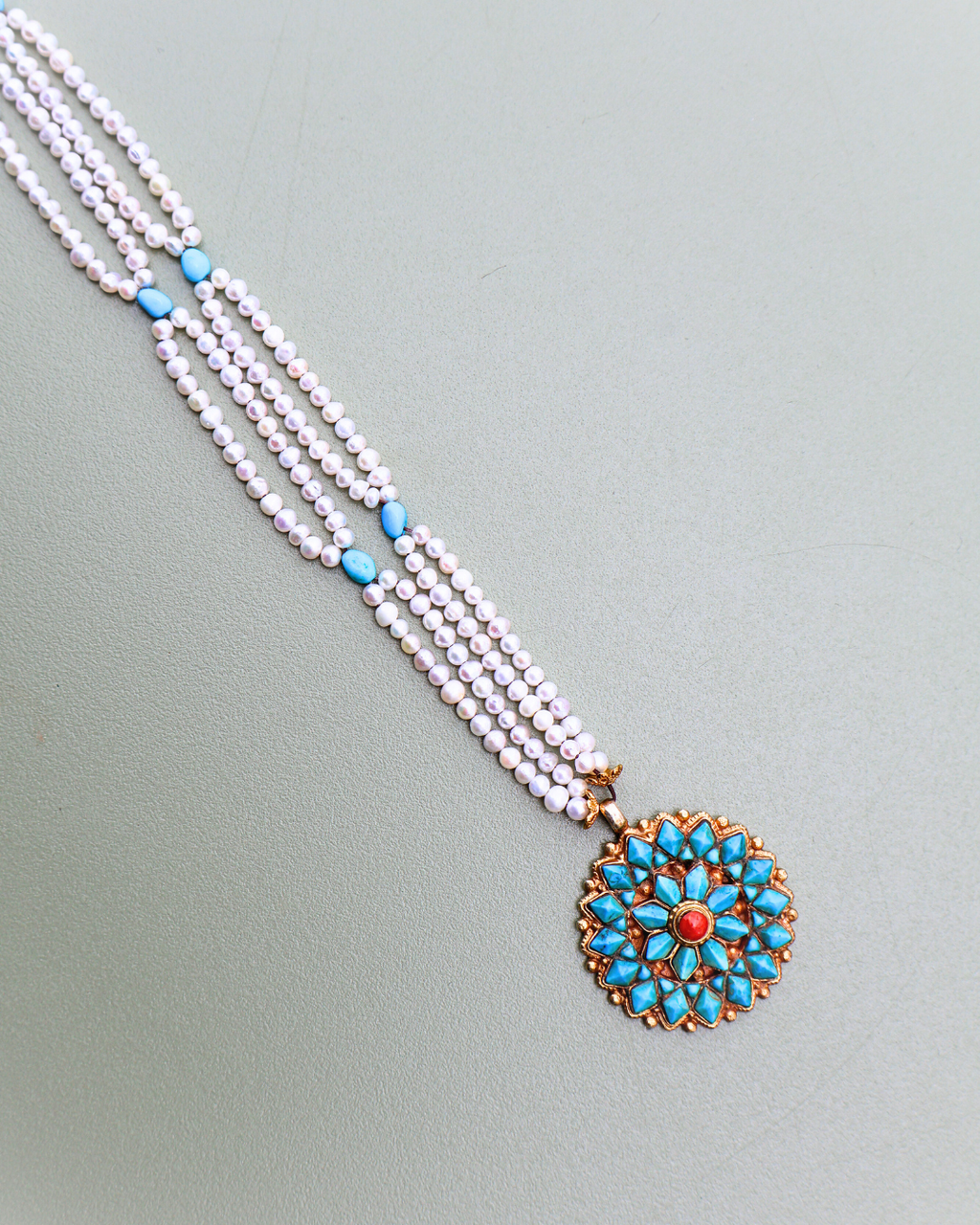 Necklace with a floral pendant on a light gray background