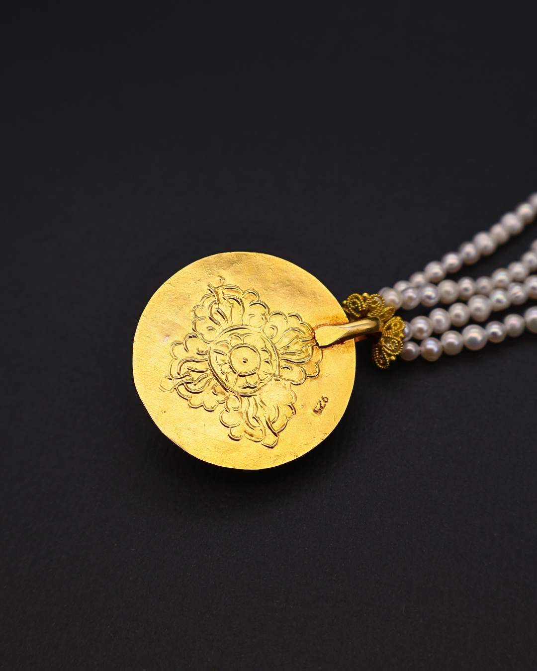 Gold pendant on a black background
