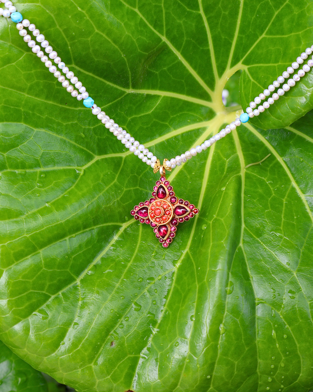 Necklace with a star-shaped pendant on a green leaf