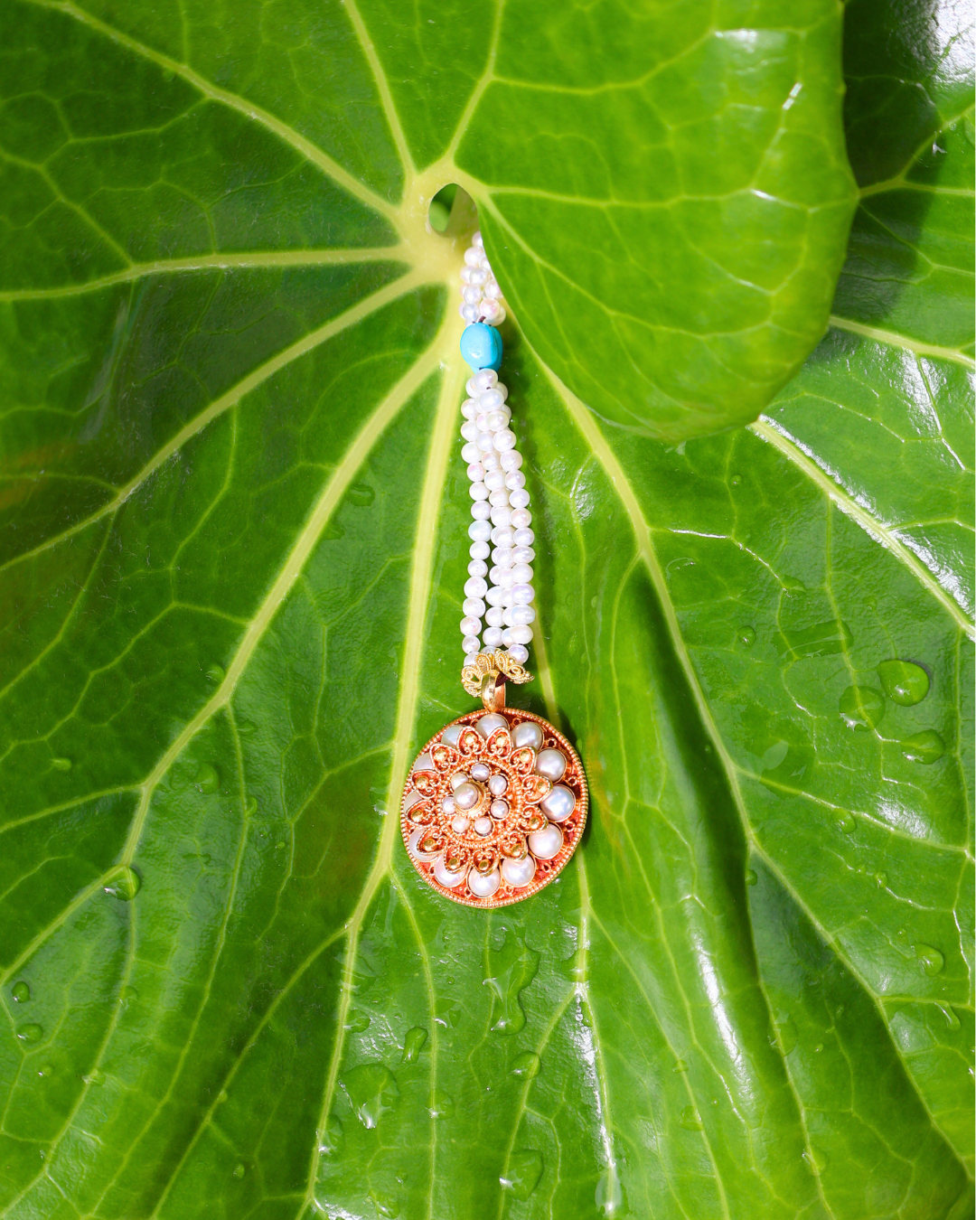 Decorative earring with a circular design on a green leaf
