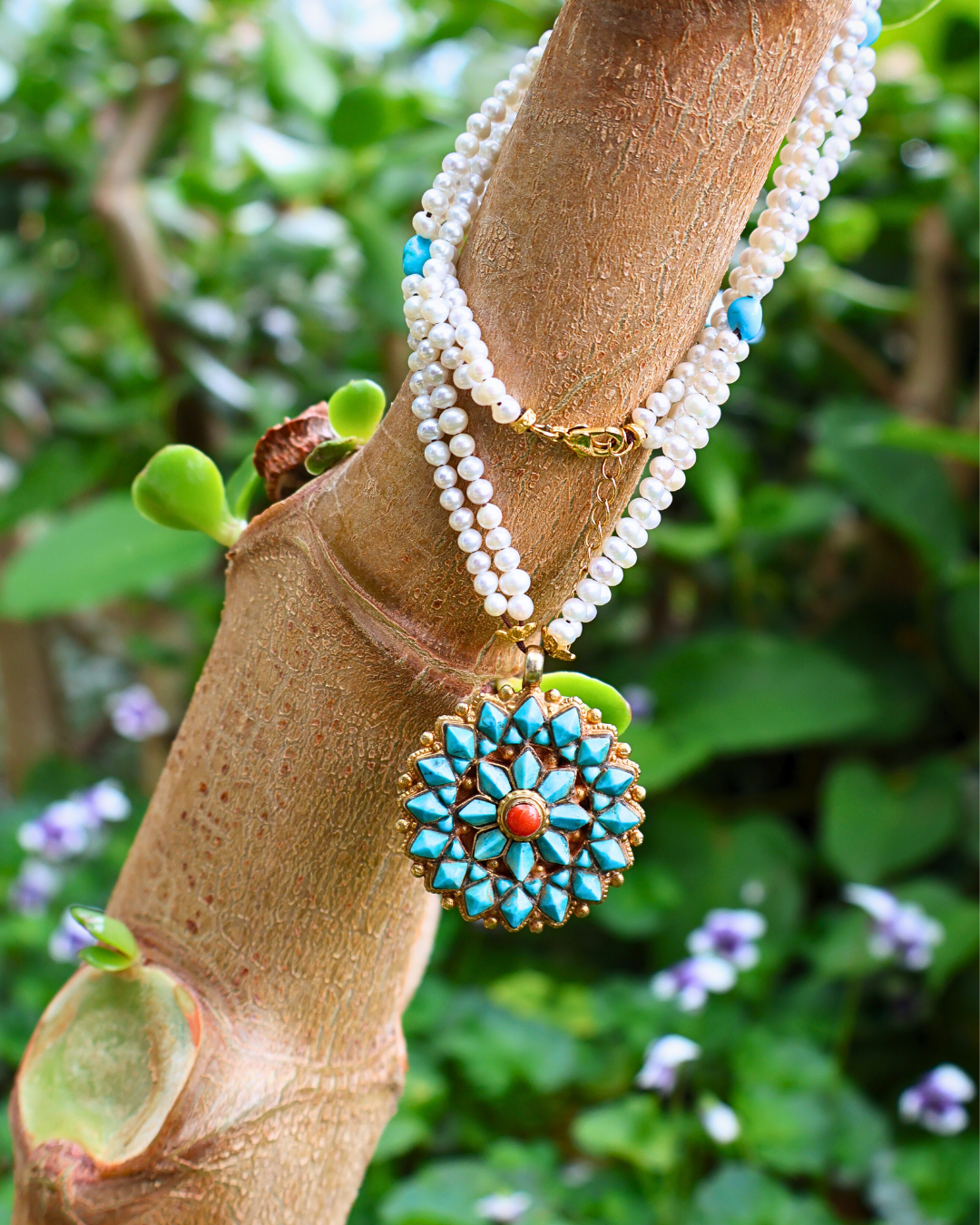 Necklace with a decorative pendant on a branch with a natural background