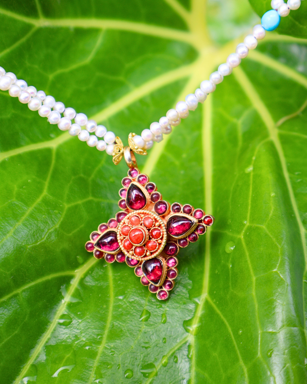 Necklace with a decorative pendant on a green leaf background