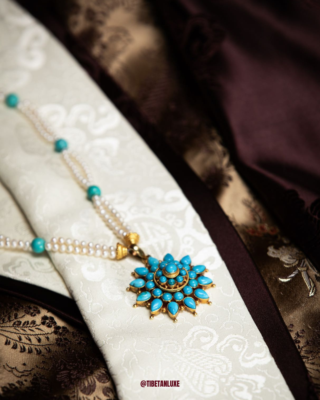 Necklace with turquoise pendant on a textured fabric background
