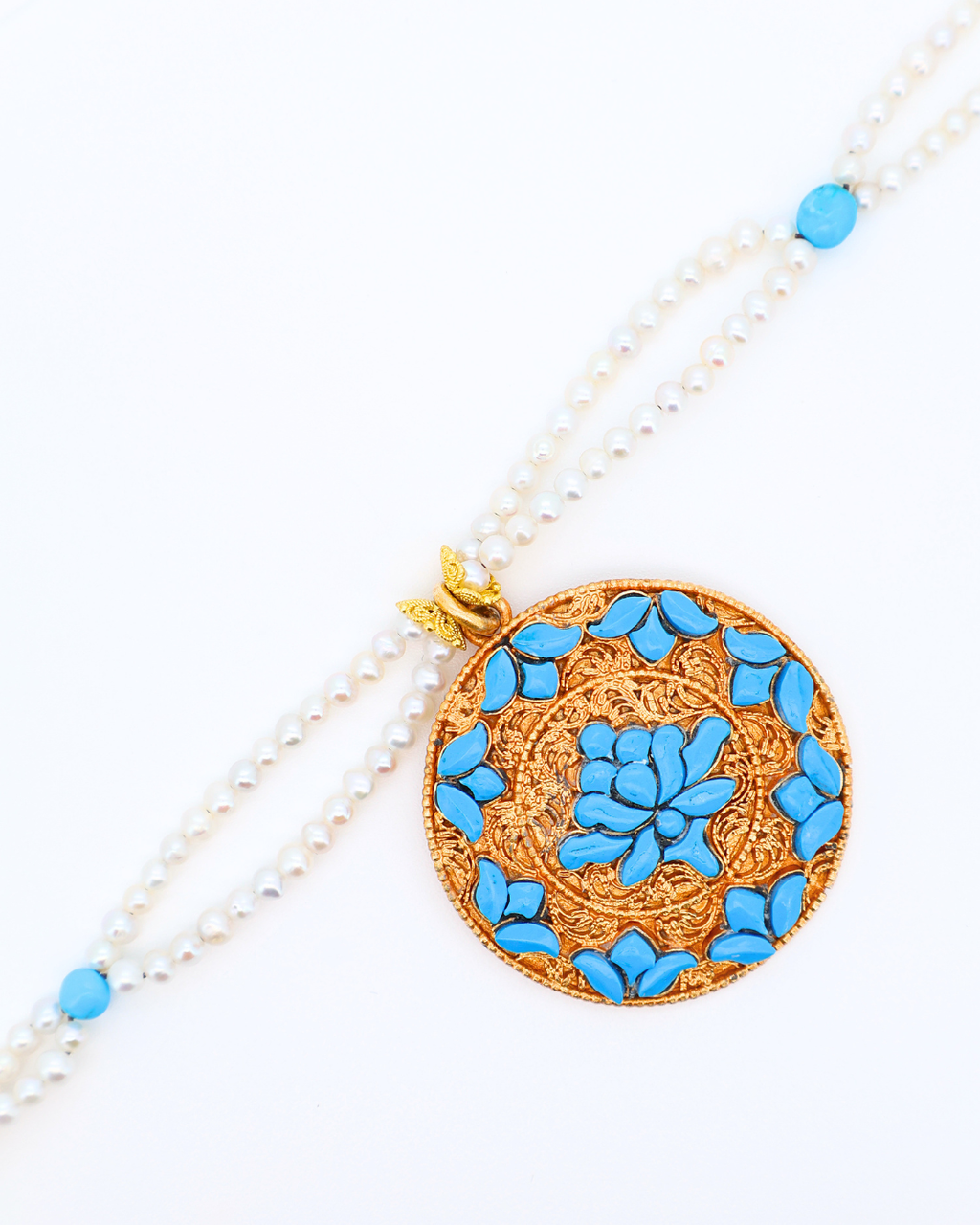 Necklace with a round pendant featuring blue floral patterns on a white background