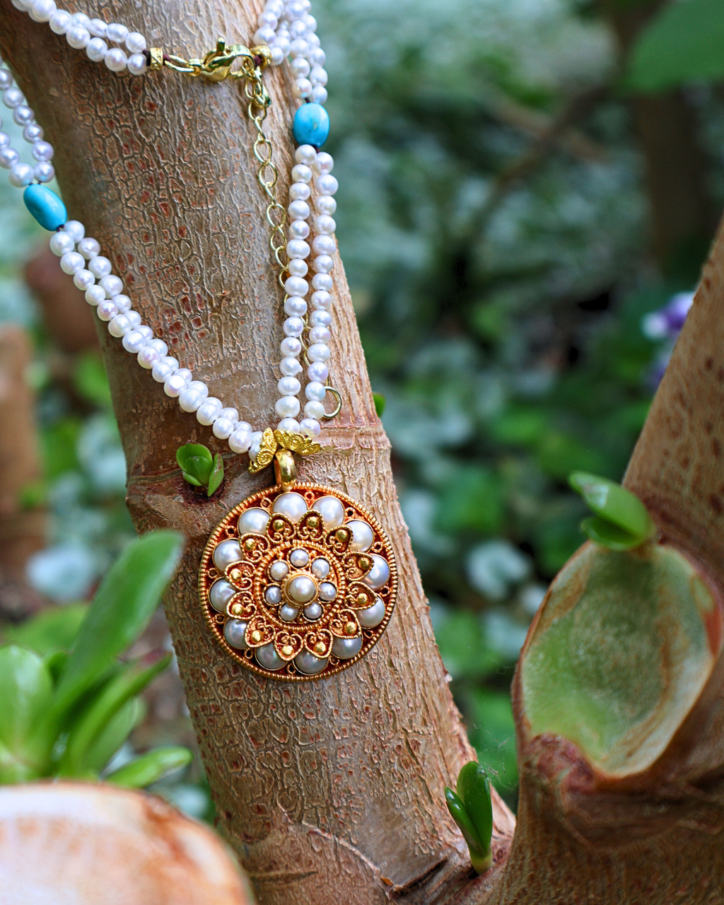 Necklace with a decorative pendant on a branch with a natural background